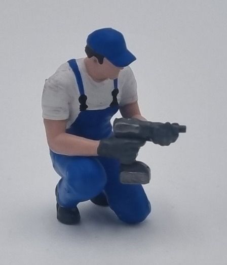 ATLAN32047_BLEU - Mechanic kneeling with an impact wrench - blue - 1