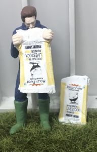 WM078K - Farmer emptying a bag of poultry food