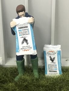 WM078L - Farmer emptying a bag of food for breeding cock