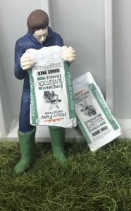 WM078M - Farmer emptying a bag of goat food